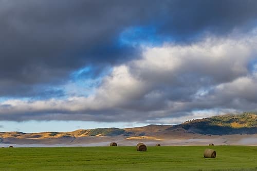 Hay bales in clearing fog with Salish Mountains in Lake County-Montana-USA Art Print